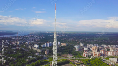 View of communication towers with blue sky, mountain and cityscape background. Video. Top view of the radio tower in the city