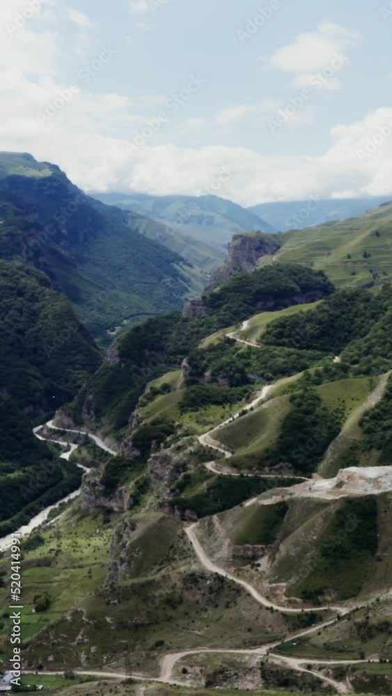 A town in lowland among hills covered with forest at foot of rocky mountains A town in lowland among hills covered with forest at foot of rocky mountains