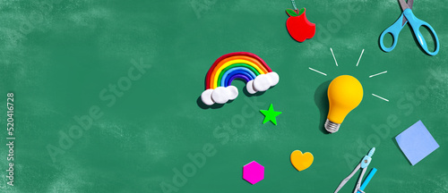 Idea light bulb with a rainbow and school supplies overhead view - flat lay