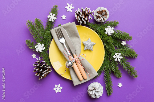 Christmas table place setting with christmas decor and plates, kine, fork and spoon. Christmas holiday background. Top view with copy space