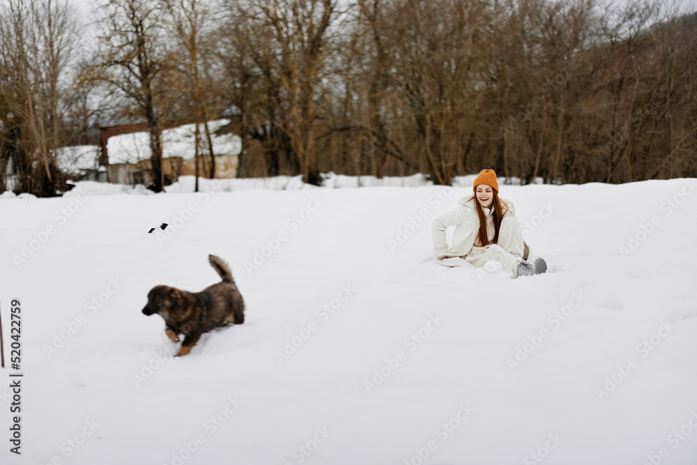 portrait of a woman outdoors in a field in winter walking with a dog Lifestyle