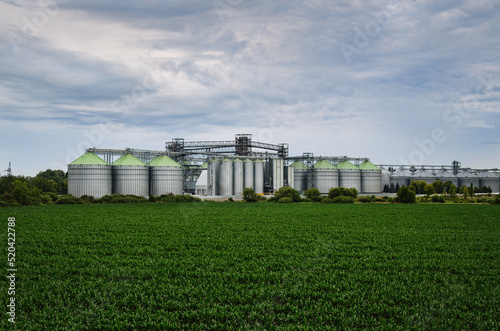 Industrial buildings and manufacturing equipment near an agricultural field. Elevator