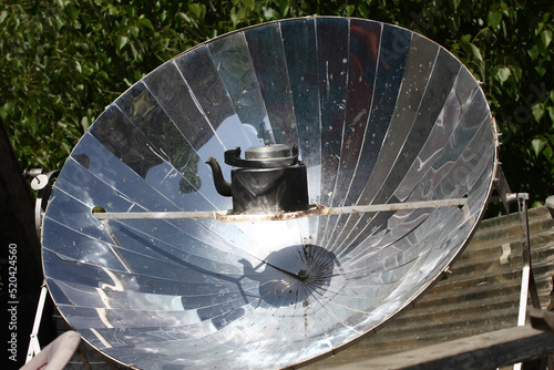 Heating a teapot by sunlight using a parabolic mirror in Nepal photo