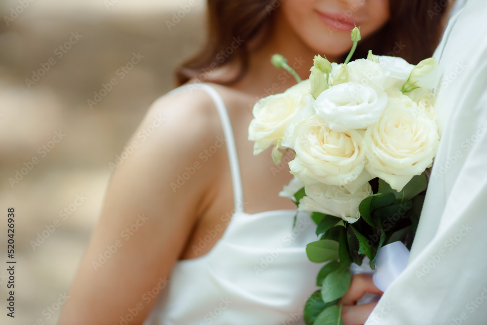 Wedding bouquet in the hands of the bride at the ceremony. Touching the hands of the bride and groom. Hugs of the newlyweds. Future married couple. The tenderness and beauty of the wedding ceremony.