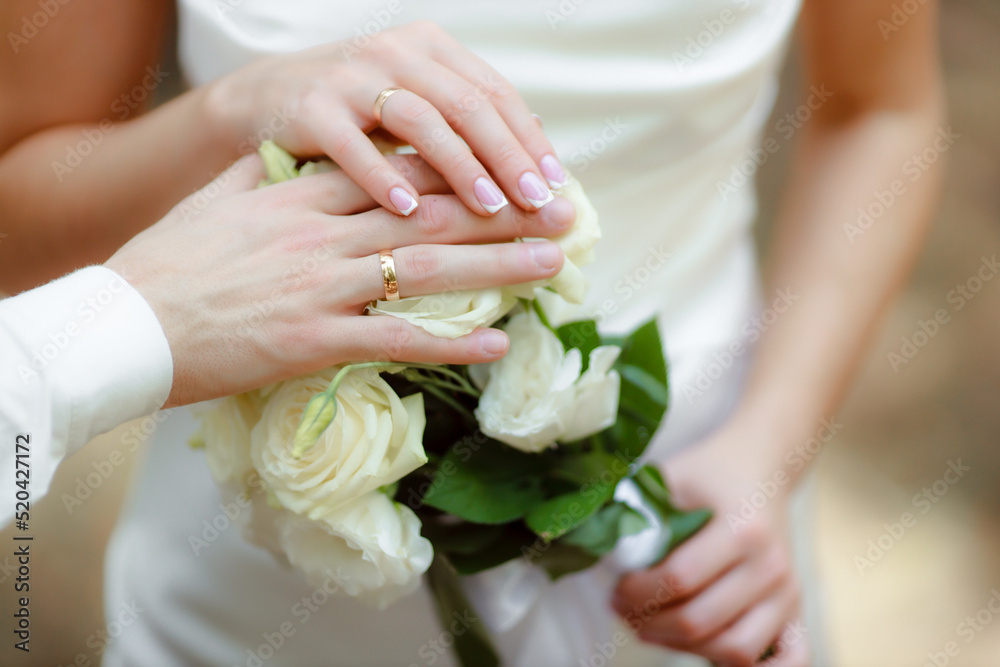 Wedding bouquet in the hands of the bride at the ceremony. Touching the hands of the bride and groom. Hugs of the newlyweds. Future married couple. The tenderness and beauty of the wedding ceremony.