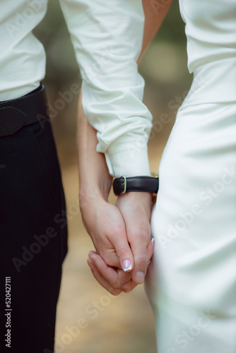 Newlyweds hold hands. Husband and wife hold each other at the wedding ceremony. The concept of a strong family. The concept of a marriage contract.