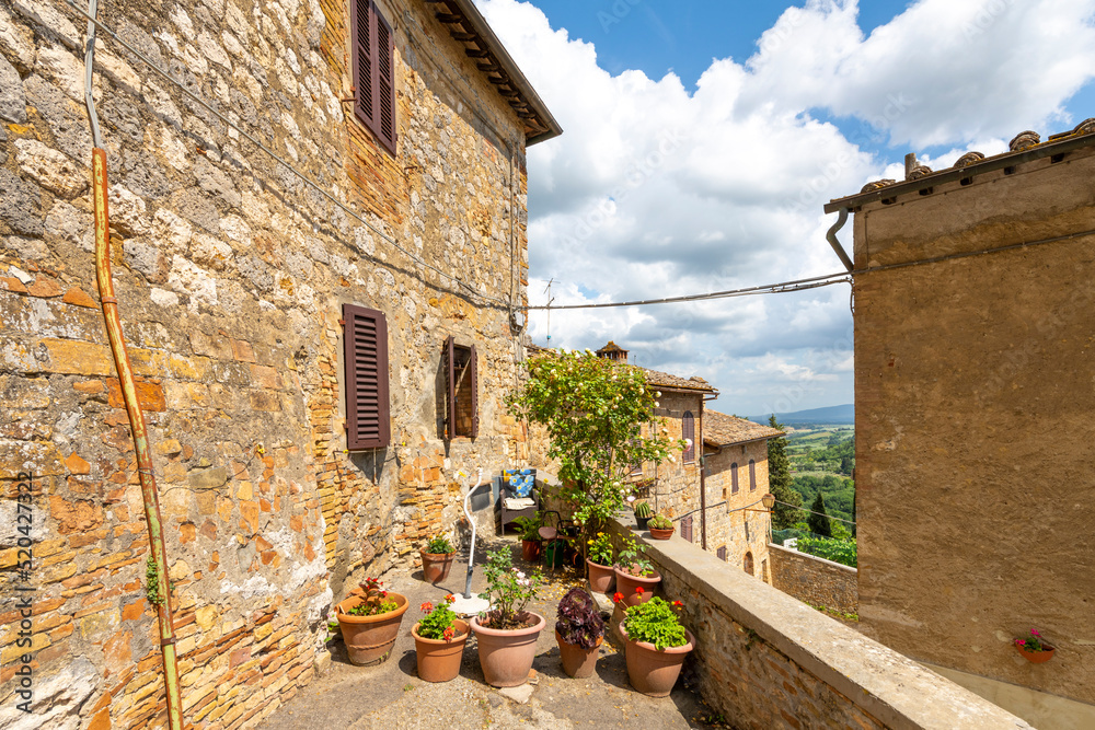 A small residential terrace along the outer wall of the Tuscan hill town of San Gimignano, Italy.