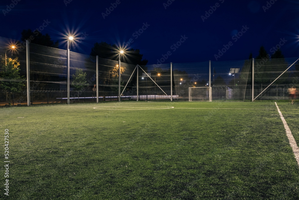 Stockfoto An amateur soccer field illuminated at night. A small