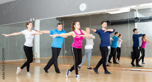 Group of adult people training in gym, doing aerobics exercises