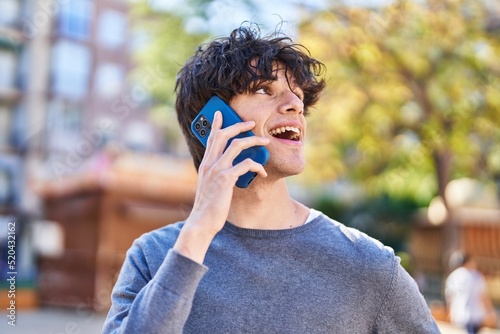 Young hispanic man smiling confident talking on the smartphone at park