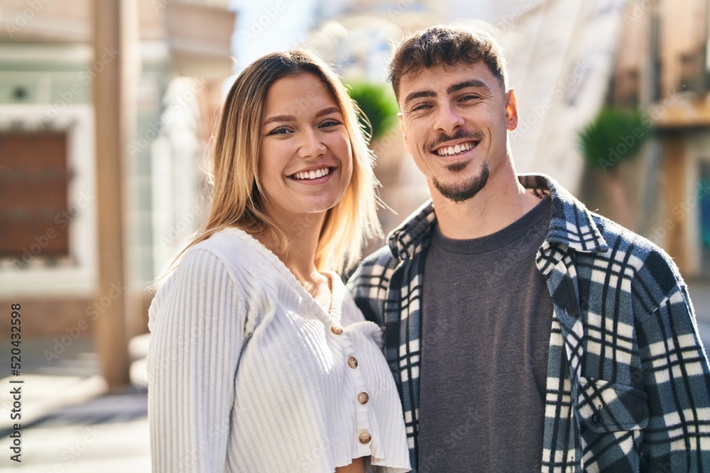 Fototapeta premium Young man and woman couple hugging each other standing at street