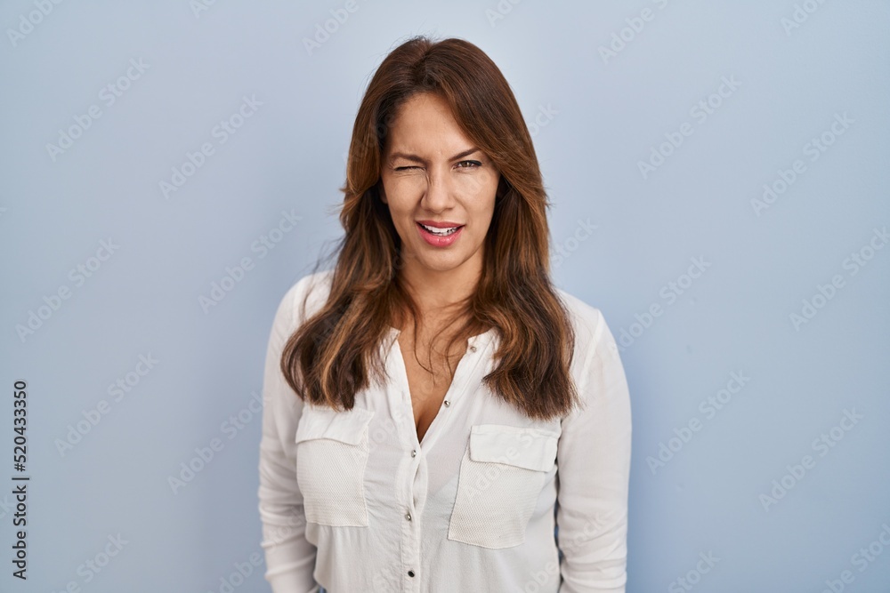 Hispanic woman standing over isolated background winking looking at the camera with sexy expression, cheerful and happy face. Hispanic woman standing over isolated background winking looking at the camera with sexy expression, cheerful and happy face.