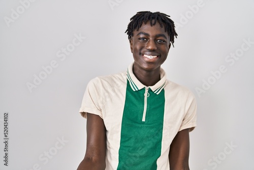 African man with dreadlocks standing over isolated background smiling cheerful with open arms as friendly welcome, positive and confident greetings