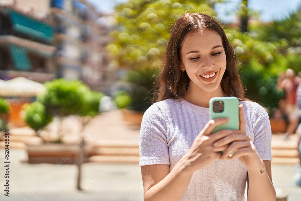 Young woman smiling confident using smartphone at park Young woman smiling confident using smartphone at park