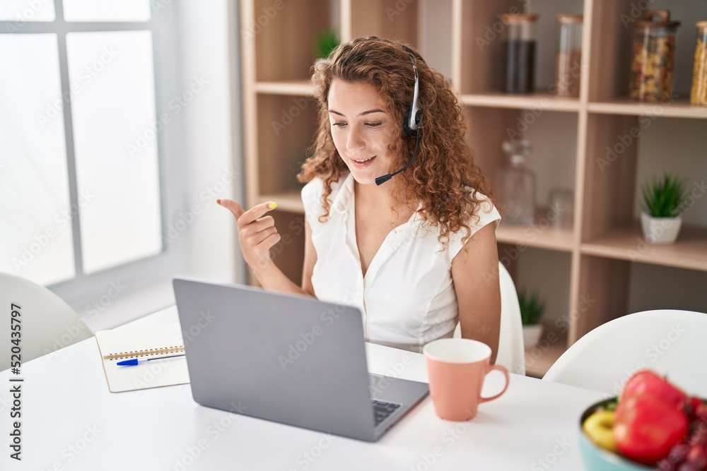 Young caucasian woman wearing call center agent headset working from home smiling happy pointing with hand and finger Young caucasian woman wearing call center agent headset working from home smiling happy pointing with hand and finger
