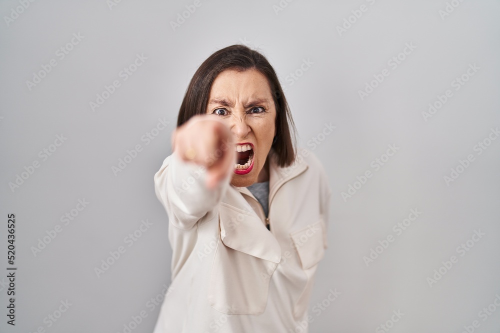 Middle age hispanic woman standing over isolated background pointing displeased and frustrated to the camera, angry and furious with you Middle age hispanic woman standing over isolated background pointing displeased and frustrated to the camera, angry and furious with you