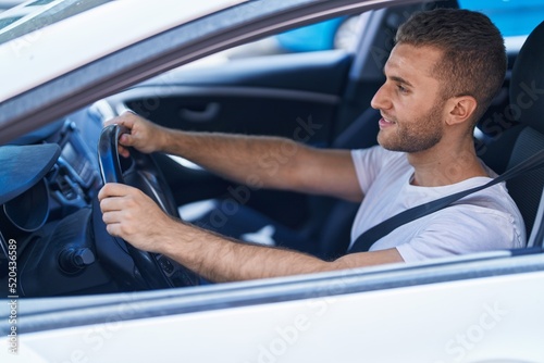 Young caucasian man smiling confident driving car at street