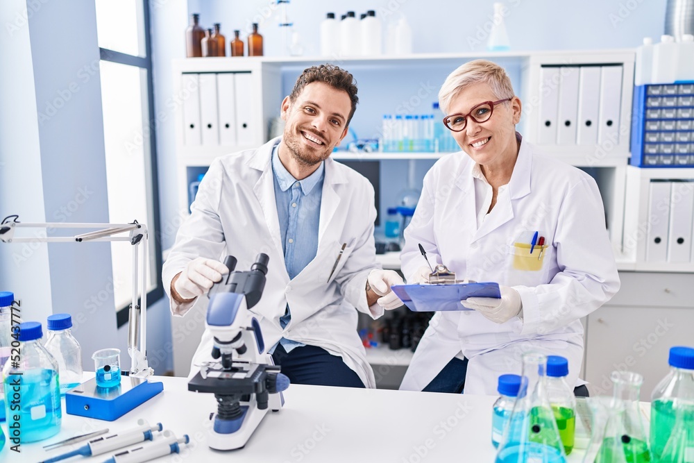 Mother and son scientist partners working at laboratory Mother and son scientist partners working at laboratory
