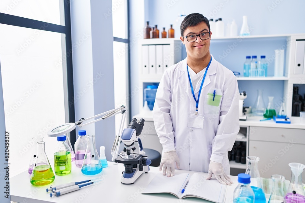 Down syndrome man wearing scientist uniform standing at laboratory Down syndrome man wearing scientist uniform standing at laboratory