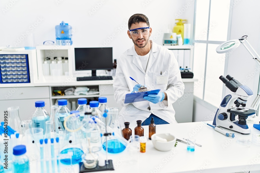Handsome hispanic man working as scientific at laboratory Handsome hispanic man working as scientific at laboratory