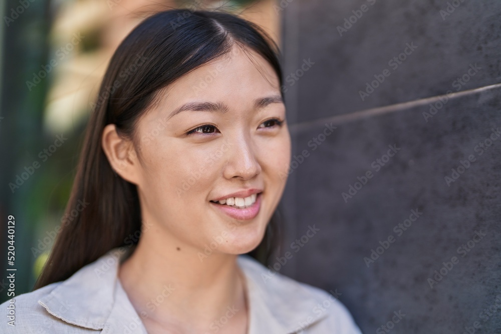 Chinese woman smiling confident looking to the side at street Chinese woman smiling confident looking to the side at street