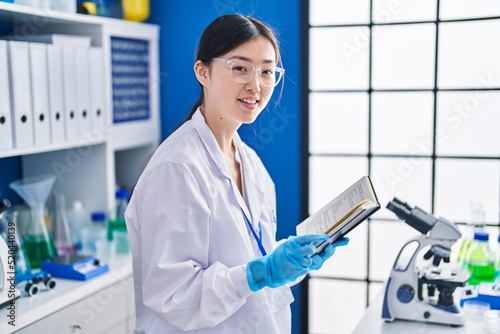Fototapeta Naklejka Na Ścianę i Meble -  Chinese woman scientist smiling confident reading book at laboratory