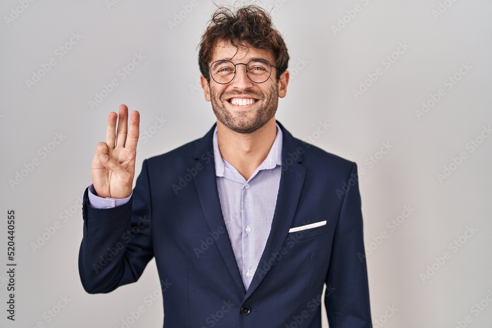 Hispanic business man wearing glasses showing and pointing up with fingers number three while smiling confident and happy. Hispanic business man wearing glasses showing and pointing up with fingers number three while smiling confident and happy.