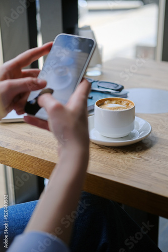 Close up of female hand's taking photo of coffee cup