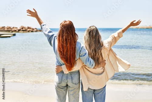 Young lesbian couple of two women in love at the beach. Beautiful women together at the beach in a romantic relationship