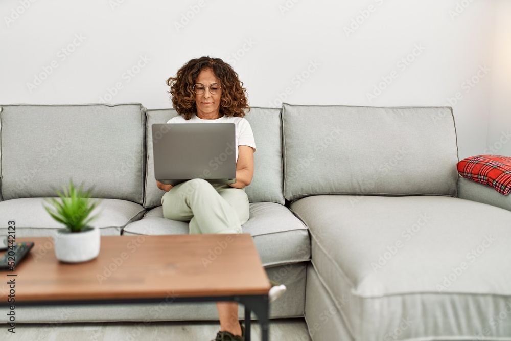 Middle age hispanic woman smiling confident using laptop at home Middle age hispanic woman smiling confident using laptop at home