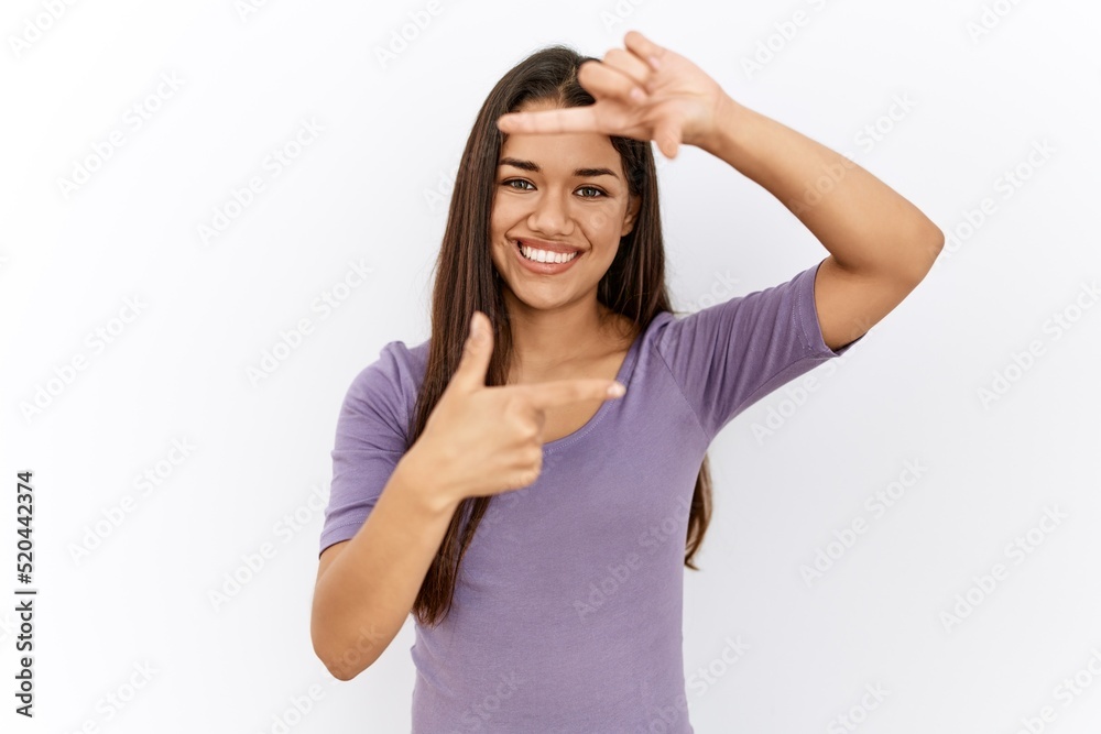 Young brunette woman standing by isolated background smiling making frame with hands and fingers with happy face. creativity and photography concept. Young brunette woman standing by isolated background smiling making frame with hands and fingers with happy face. creativity and photography concept.