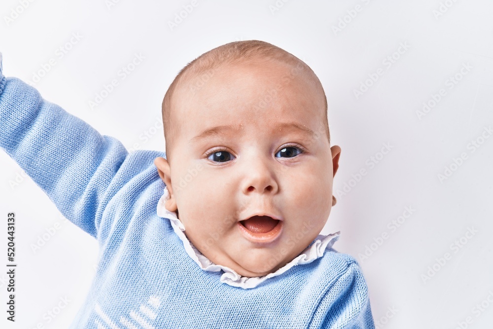 Adorable baby smiling confident lying on bed over white isolated background Adorable baby smiling confident lying on bed over white isolated background