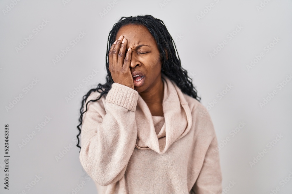 African woman standing over white background yawning tired covering half face, eye and mouth with hand. face hurts in pain. African woman standing over white background yawning tired covering half face, eye and mouth with hand. face hurts in pain.