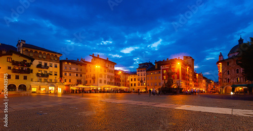 View of busy central city square Piazza Duomo in autumn evening, Trento, Italy.