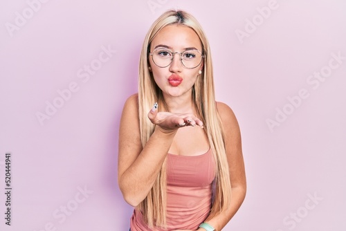 Φωτογραφία Young blonde girl wearing casual clothes looking at the camera blowing a kiss with hand on air being lovely and sexy