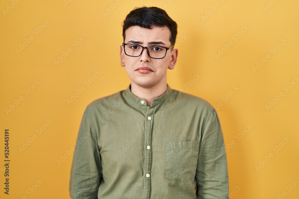 Non binary person standing over yellow background depressed and worry for distress, crying angry and afraid. sad expression. Non binary person standing over yellow background depressed and worry for distress, crying angry and afraid. sad expression.
