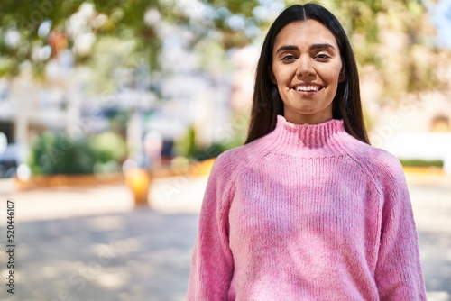 Young hispanic woman smiling confident standing at park