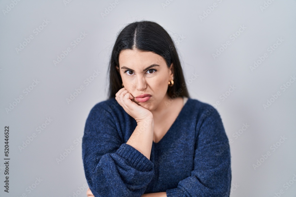 Young brunette woman standing over isolated background thinking looking tired and bored with depression problems with crossed arms. Young brunette woman standing over isolated background thinking looking tired and bored with depression problems with crossed arms.