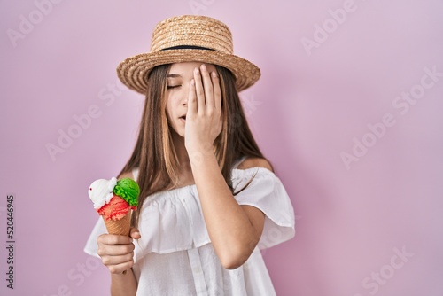 Teenager girl holding ice cream yawning tired covering half face, eye and mouth with hand. face hurts in pain.