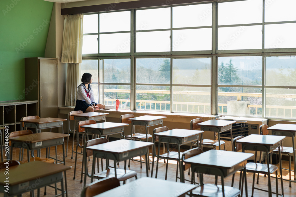 窓際で外を見る女子高生 窓際で外を見る女子高生
