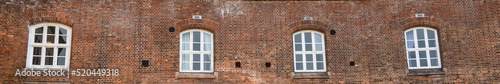 Row of arched windows in the red brick wall of Oscarsborg Fortress, historic WW2 site in Norway 
