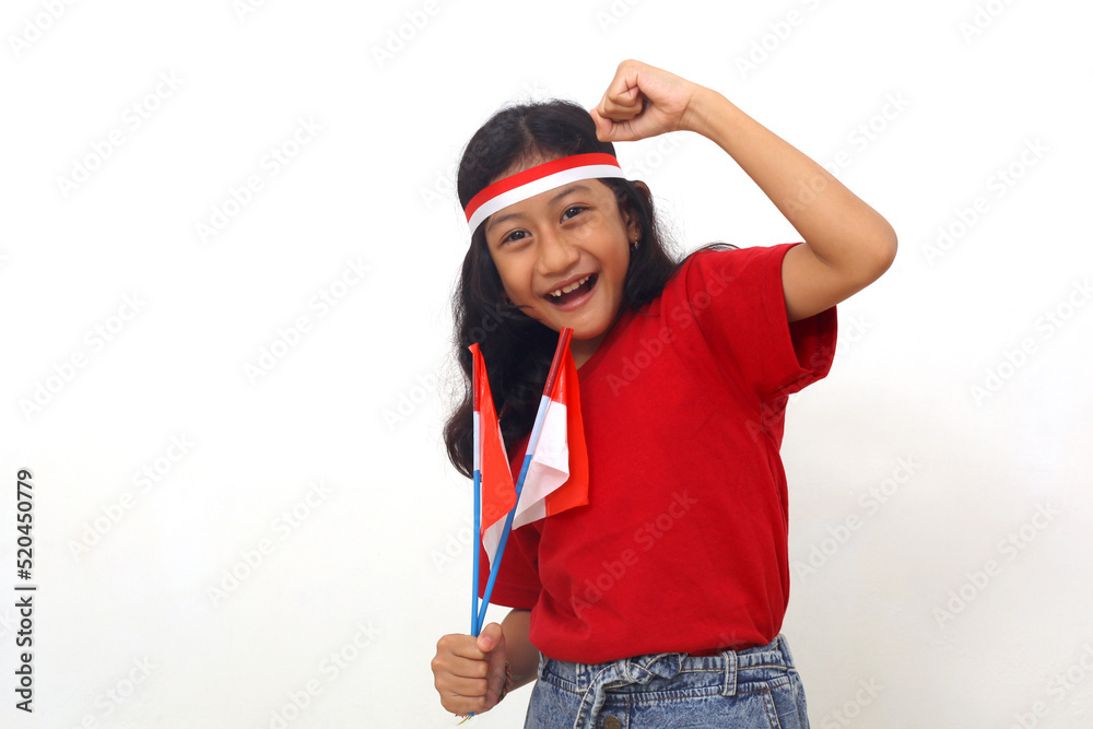 Happy Asian girl standing while holding indonesian flag to celebrate independence day Happy Asian girl standing while holding indonesian flag to celebrate independence day