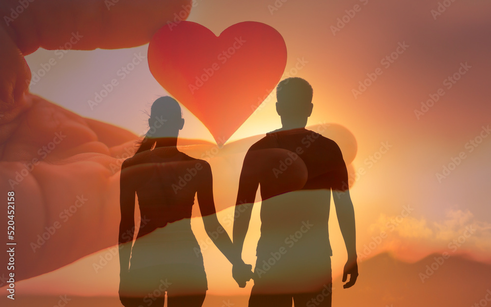 Couple holding hands facing the sunrise. Love and relationship symbol 