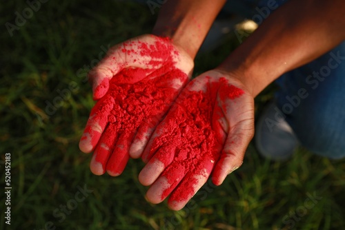 African American man with red powder dye outdoors, closeup. Holi festival celebration photo