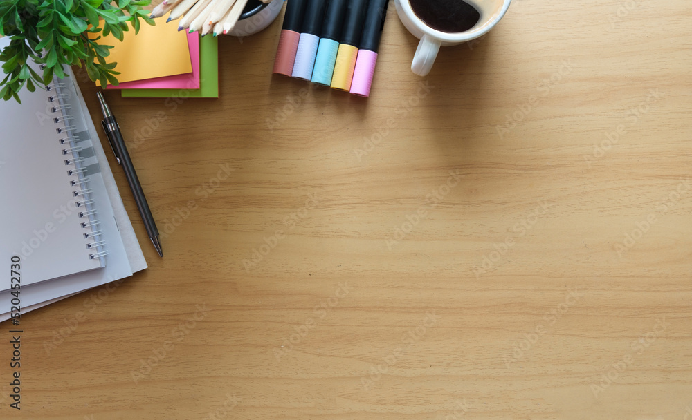 Above view stationery, potted plant, and coffee on wooden table. Flat lay, top view with copy space. Above view stationery, potted plant, and coffee on wooden table. Flat lay, top view with copy space.