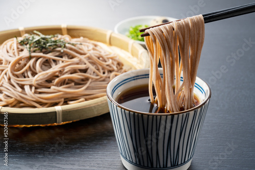 Zaru-soba placed on a black background. Soba noodles dipped in noodle soup.