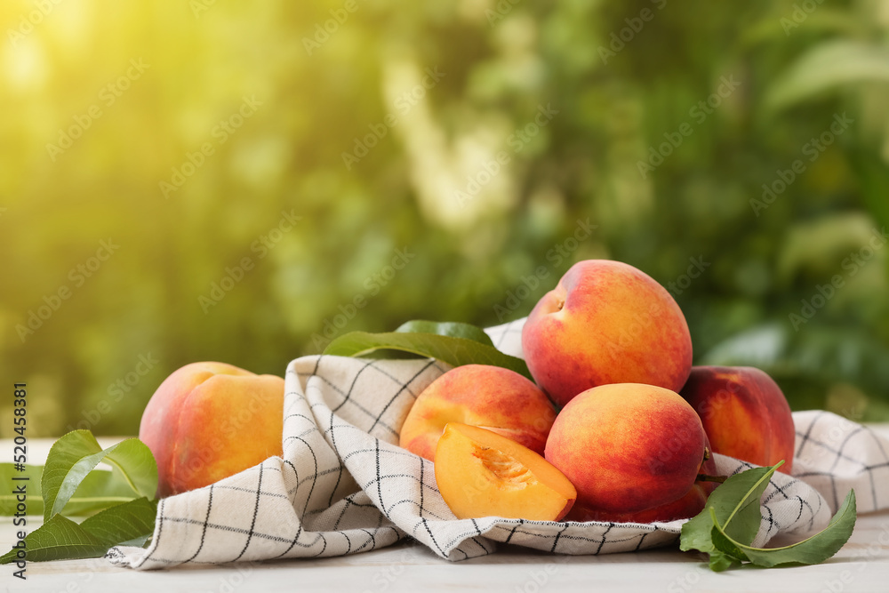 Sweet ripe peaches on table outdoors - obrazy, fototapety, plakaty 