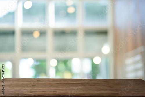 Abstract bokeh sunlight and window background of nature in green color with wooden table.	 