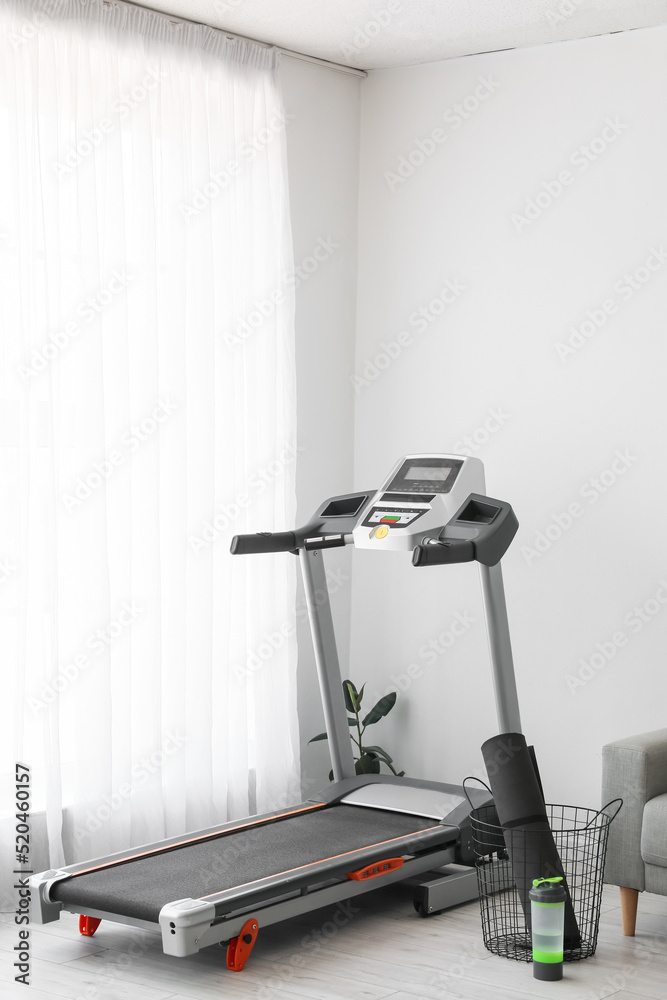 Modern treadmill in interior of light living room Modern treadmill in interior of light living room