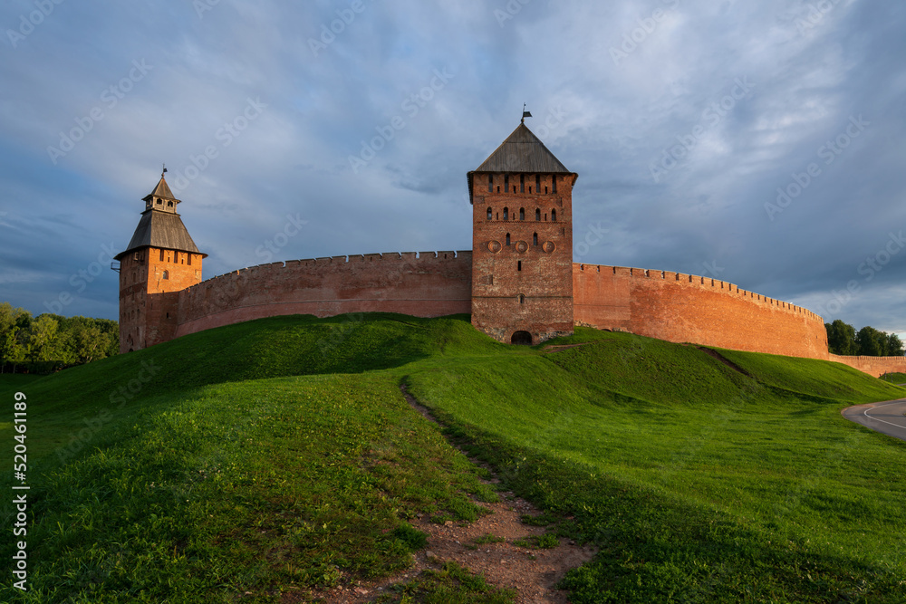View of the wall of the Novgorod Kremlin, the Dvortsovaya and Spasskaya Towers on an early cloudy summer morning, Veliky Novgorod, Novgorod region, Russia